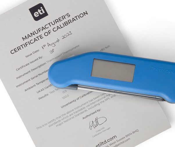 Close up of a blue Thermapen Classic laying on a Manufacturer's Certificate